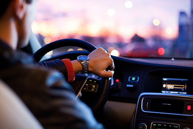 A man drives a car at sunset, symbolizing the protection CarGuard can offer